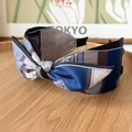 Detailed view of color-block satin knotted headband with geometric texture on wood plate - Bow Headband / Color Block Blue Grey