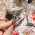 Detalle de anillo de corona plateado con gema azul en forma de gota en la mano - Abierto Ajustable / Plata Zirconia Azul Mar