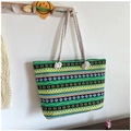 Detailed view of leaf pattern canvas beach bag with beige cotton rope handles hanging on hook - Green Yellow Blue Ethnic Pattern