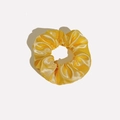 Macro detail of glossy yellow satin scrunchie showing fabric texture and elastic pleats - Satin 14 (Yellow)
