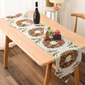 Detailed view of a knitted Christmas table runner featuring wreath and bow patterns - Knit Garland Style