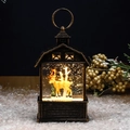 Close-up of a bronze vintage Christmas lantern with golden reindeer and forest scene - Antique Gold Reindeer and Branches