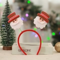 Detail of Christmas headband with Santa dolls on spring decorations and festive background - Santa Claus / Red