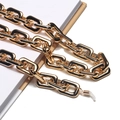 Nahaufnahme einer dicken goldenen Brillenkette aus Metall mit Silikonhaken auf einem Buch - Gold