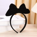 Diadema con lazo grande 3D de terciopelo negro para mujer sobre fondo minimalista - Negro