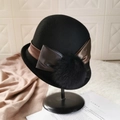 Eleganter Glockenhut aus schwarzer Wolle mit braunem Satinband und Pelzbommel-Detail - Pompon Rollrand Schleife / Schwarz
