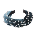 Close-up of a dark green velvet headband featuring a knotted design and white pearls - Blue Grey