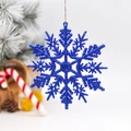 Sparkling blue glitter snowflake ornament hanging on a Christmas tree branch - Blue