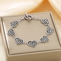 Detail of silver stainless steel knot heart bracelet with black enamel inlay and OT clasp - Silver (KB186691-GC)
