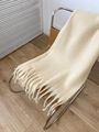 Écharpe épaisse en mohair crème avec de longues franges sur une chaise pour l'hiver - Beige