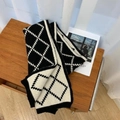Klassischer schwarz-weißer Strickschal mit Karomuster auf einem Holztisch präsentiert - Schwarz & Beige Argyle