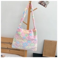 Pink plush tote bag with colorful flower patterns hanging on a wooden hanger - Pink