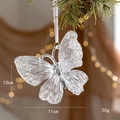 Transparenter Acryl Schmetterling mit Silberglitzer hängend an einem Tannenbaum - Schmetterling