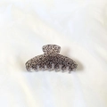 Dettaglio di una molletta per capelli con stampa leopardata su tessuto bianco - Grigio