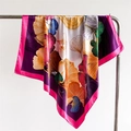Detailed view of silky satin scarf with colorful ginkgo leaf print hanging on metal hanger - 90x90cm / Purple