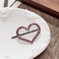 Macro di un fermaglio per capelli a cuore argento con strass rosa su piatto bianco - Cuore Rosso Rosa