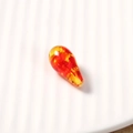 Detailed close-up of a teardrop-shaped amber resin bead with colorful gradient finish - 1 Piece / Transparent Pattern