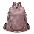 Detail view of dusty pink retro backpack featuring woven strap and tassel charm - Pink