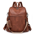 Close-up of brown vintage leather backpack with fringe detail and striped strap - Brown
