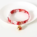 Close-up of red cherry blossom pet collar with gold bell on white ceramic plate - S (17-32cm) / Red Japanese Style