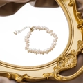 Close-up of Baroque freshwater pearl bracelet with gold clasp on vintage mirror - A Bracelet Style