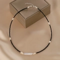 Minimalist black beaded necklace with white baroque pearls on a beige silk background - Black Bead and White Baroque Pearl Necklace (W-b-009)