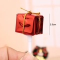Close-up of 2.5cm red miniature gift box cake topper with gold ribbon on white stick - Red Gift Box