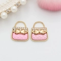 Vista macro di due ciondoli a borsa rosa placcati in oro con perle per gioielli fai da te - Rosa