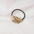 Detail of a minimalist black hair tie with a textured metallic golden feather charm - Feather Shape (4) / Gold