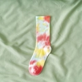 Vibrant tie-dye cotton crew socks in red and yellow pattern displayed on green fabric - One Size / Red Multi Tie Dye
