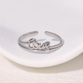 Anillo abierto plateado minimalista con letras LOVE en acero inoxidable pulido - Color Acero