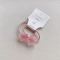 Close-up of pink star charms on spiral elastic hair ties in branded card packaging - Light Pink Star Hair Tie