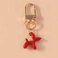 Macro detail of glossy red balloon dog keychain with gold metallic lobster clasp - Red