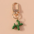 Detail of green balloon dog keychain with golden metal ring on a soft pink background - Dark Green