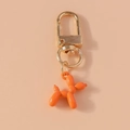 Dettaglio del portachiavi a forma di cane palloncino arancione con chiusura in metallo dorato - Arancione