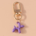 Macro shot of a purple balloon dog keychain with high-quality gold metal lobster clasp - Purple