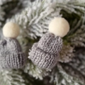 Mini bonnets de Noël gris tricotés avec pompon blanc sur branches de pin hivernales - Gris clair