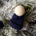 Mini navy blue knitted Christmas hat with cream pompom on decorative snowy branch - Dark Blue