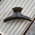 Detail view of a 11cm semi-transparent black curved hair claw clip on a display tray - Dark Tea Grey