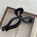 Close-up of a glossy black bow hair claw clip featuring Only Belong To You lettering - Glossy Black Bow Claw