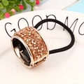 Champagne rhinestone ponytail cuff hair ring with black elastic band on white plate - Zirconia Style / Gold