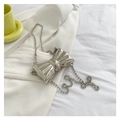 Detail view of silver bow-shaped metallic mini crossbody bag with pearl chain strap - Silver Style 5 (Bead Chain Strap)
