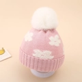 Detailed knit texture of pink baby winter hat featuring a white floral pattern and faux fur pom - 0-12 Months / Pink