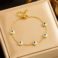 Elegant gold-plated stainless steel Evil Eye bracelet displayed in a luxury jewelry box - Bracelet (B1384)