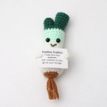 Detailed knit of a crochet positive scallion doll holding an encouraging message card - Scallion with Brown Roots