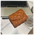 Elegante braune gesteppte Leder-Geldbörse, dreifach faltbar auf reflektierender Oberfläche - Braun