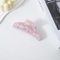 Pink marble texture acetate banana hair clip displayed with a white candle and book - Light Floral