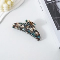 Macro detail of crescent acetate hair claw with blue and brown tortoiseshell pattern - Black and White Speckled