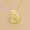 Macro shot of gold nautilus shell pendant with spiral texture on twisted rope chain - Conch Pendant (B)