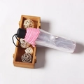Detalle de un mini paraguas plegable rosa con mango negro en su funda de protección - Manual/Tres Pliegues / Rosa Estándar